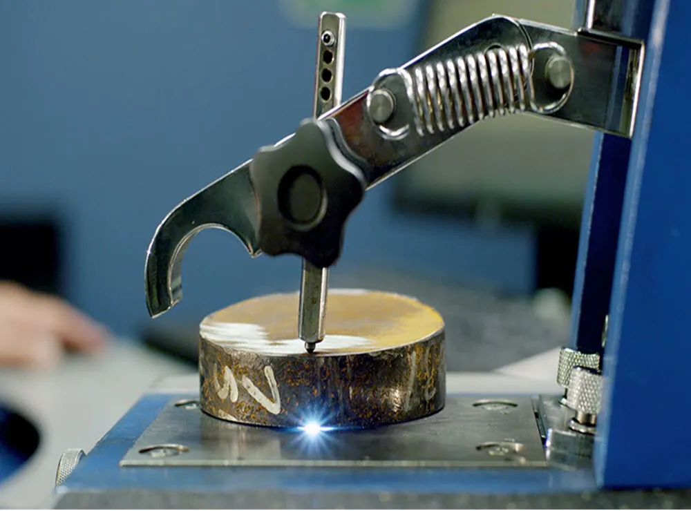 Metal specimen under test on a hardness testing machine in the laboratory
